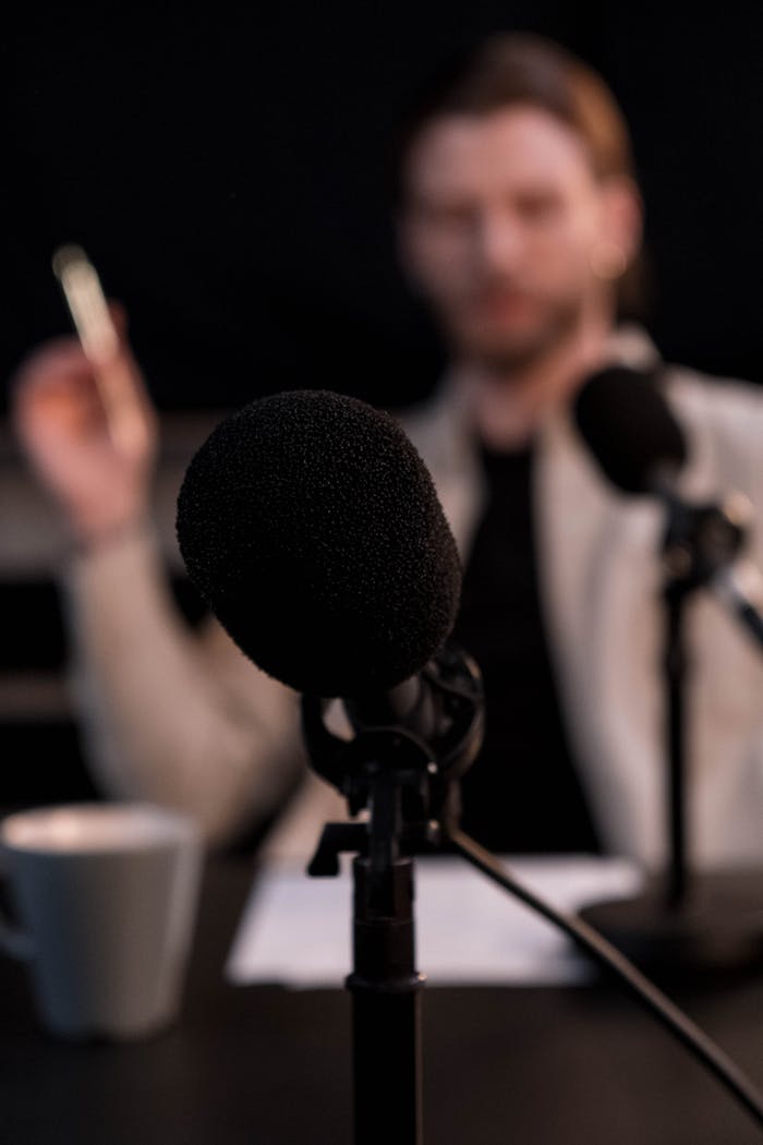Close-up of a microphone with a blurred background, ideal for podcast themes.